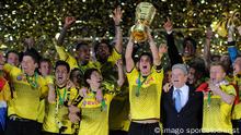 Dortmund captain Sebastian Kehl holds up the German Cup as he celebrates with teammates.