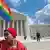 Молодой человек с радужным флагом около Верховного суда США