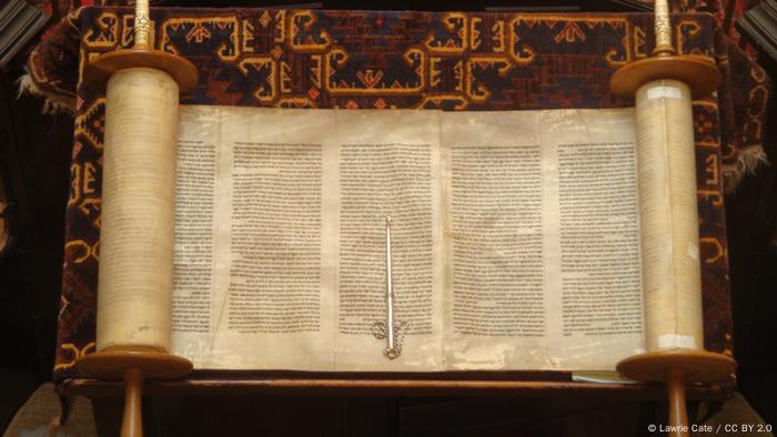 Foto: Eine geöffnete Thora-Rolle auf rotem Untergrund (Foto: CC BY 2.0: Lawrie
Cate)