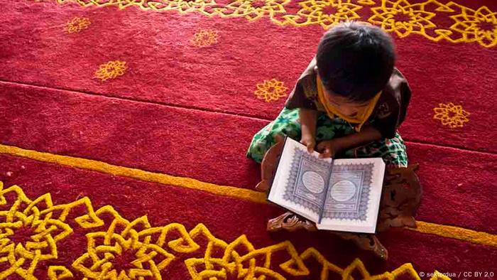 Foto: Ein Kind sitzt mit einem Koran auf einem roten Teppich (Foto: CC BY 2.0:
sektordua)