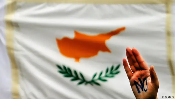 A student raises her hand by a Cypriot flag during an anti-Troika protest outside the Presidential palace in Nicosia March 26, 2013. The chairman of Cyprus's biggest commercial bank offered his resignation and thousands of students protested in the capital as banks stayed shut to stop a run on deposits after the island agreed a painful bailout to avert bankruptcy. REUTERS/Yannis Behrakis (CYPRUS - Tags: BUSINESS POLITICS CIVIL UNREST)