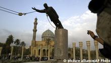 FILE - A U.S. Marine watches a statue of Saddam Hussein being toppled in Firdaus Square in downtown Baghdad on April 9, 2003 file photo. (AP Photo/Jerome Delay, File)
