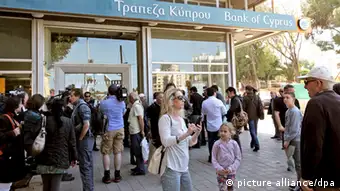 epa03643279 Customers and media representatives wait outside a branch of the Bank of Cyprus, in Nicosia, Cyprus, 28 March 2013 morning. All of the country's 26 banks were open from 12 pm until 6 pm (1000-1600 GMT) on 28 March with a withdrawal limit set at 300 euros (383 dollars) per person. Cyprus was braced for the reopening of its banks after nearly two weeks, after the government imposed tough capital controls for at least the next seven days. Police were going from bank to bank in central Nicosia to prevent problems, while dozens of people had started to queue in front of the banks' doors. EPA/KATIA CHRISTODOULOU