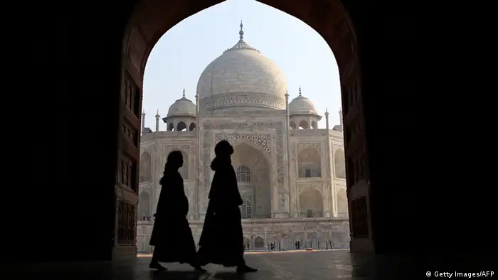 Indian tourists walk past an archway at the historic Taj Mahal in Agra on November 28, 2012. A highway, that opened up in August 2012, connecting India's Taj Mahal tourism town of Agra with the capital New Delhi has slashed driving time by more than half. The 165-kilometre (100-mile) Yamuna Expressway promises a two-hour drive through the crowded towns of Uttar Pradesh state to Agra, where the Taj Mahal draws almost three million domestic and foreign tourists a year. AFP PHOTO/ Andrew Caballero-Reynolds (Photo credit should read Andrew Caballero-Reynolds/AFP/Getty Images)
