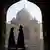 Indian tourists walk past an archway at the historic Taj Mahal in Agra on November 28, 2012.