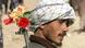 An Afghan with flowers in the barrel of his Kalashnikov rifle slung over his shoulder, An Afghan with flowers in the barrel of his Kalashnikov rifle slung over his shoulder,