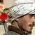 An Afghan with flowers in the barrel of his Kalashnikov rifle slung over his shoulder,
