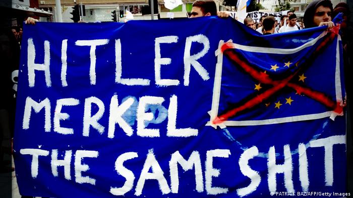 Cypriot college students holding a banner comparing German Chancellor Angela Merkel to Nazi dictator Adolf Hitler (Photo: PATRICK BAZ/AFP/Getty Images)