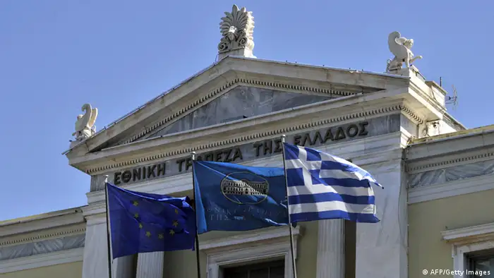 EU, National Bank and Greek flags float in front of the facade of the headquarters of the National Bank of Greece on September 23, 2011. Moody's credit rating agency downgraded the ratings of the main Greek banks by two notches on September 23, 2011, citing increased risks of losses on their holdings of Greek debt. Moody's Investors Service also warned of an increased prospect that the Greek economy will worsen. AFP PHOTO / LOUISA GOULIAMAKI (Photo credit should read LOUISA GOULIAMAKI/AFP/Getty Images)