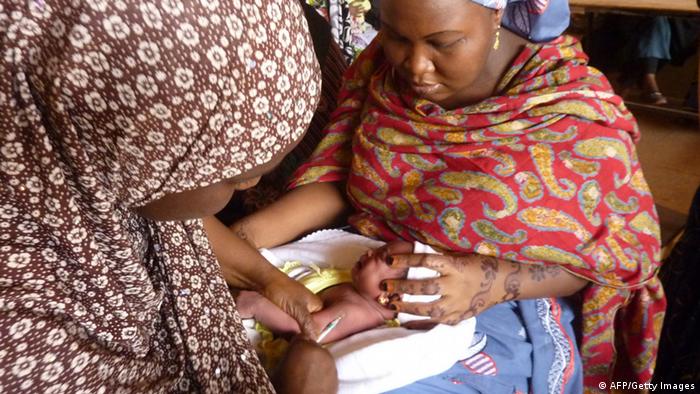 A health worker vaccinates a child at a health centre in Kano, northern Nigeria