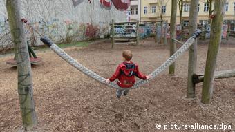 Illustration - Ein fünfjähriger Junge sitzt allein auf einer Schaukel auf einem Abenteuerspielplatz in Berlin, aufgenommen am 10.4.2012. Foto: Jens Kalaene