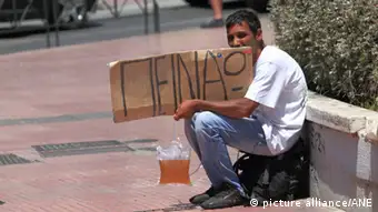 Athen - Panepistimiou Strasse Ein Bettler sitzt an der Panepistimiou-Strasse in Athen, Griechenland, mit einer Papptafel mit der Aufschrift: Peinao - Ich habe Hunger. *** Local Caption ***