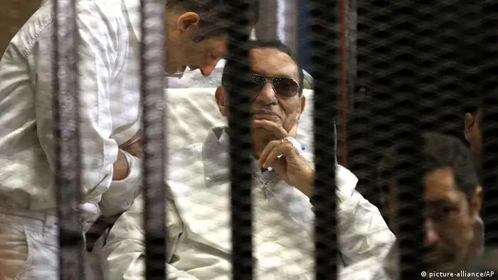 epa03660527 Gamal Mubarak (L) and brother Alaa Mubarak (R), with their father former Egyptian President Hosni Mubarak in a cage inside the court room during his trial at the Police Academy in Cairo, Egypt, 13 April 2013. A judge presiding over the retrial of former Egyptian president Hosny Mubarak on charges related to the 2011 deaths of protesters withdrew from the case as it started 13 April 2013. Judge Mustafa Hassan said as the new trial started that he was feeling 'uneasiness' about hearing the case and would refer the case back to the Appeals Court so it could name a new judge. EPA/KHALED ELFIQI