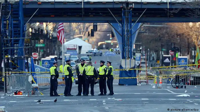 epa03663991 Police officers stand near the finish line of the Boston Marathon as an investigation continues into dual bombings at the site, in Boston, USA, 16 April 2013. Three people were killed and over 100 were injured when two bombs exploded on 15 April 2013 at the finish line of the marathon. EPA/JUSTIN LANE