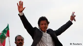 Imran Khan, Pakistani cricketer-turned-politician, Chairman of political party Pakistan Tehreek-e- Insaf (PTI) waves to his supporters during a rally in Lahore March 23, 2013. Khan, speaking to tens of thousands of party supporters on Saturday, vowed to be truthful and loyal with them even after assuming powers in run up to a historic national election later this spring before heavy rain interrupted his speech, local media reported. REUTERS/Mohsin Raza (PAKISTAN - Tags: POLITICS SPORT CRICKET)