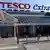 People carry shopping bags through the carpark of a Tesco Extra supermarket