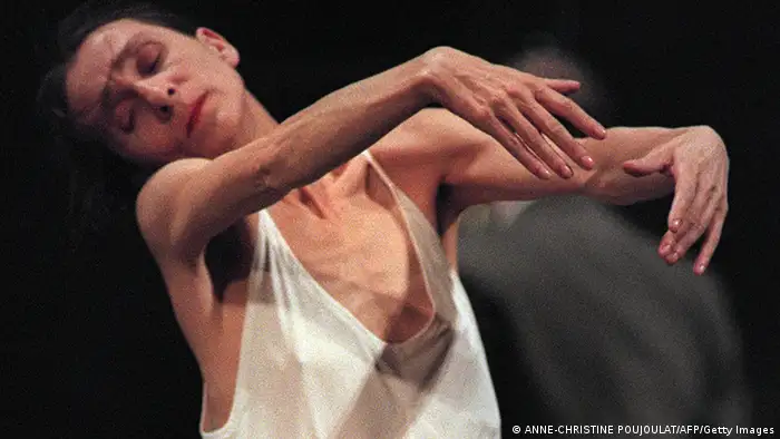 Pina Bausch in weißem Hemd tanzt geschmeidig, mit geschlossenen Augen.

(c) BERTRAND GUAY/AFP/Getty Images

