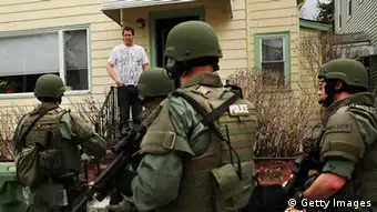 WATERTOWN, MA - APRIL 19: Members of a police SWAT team talk to a man while conducting a door-to-door search for 19-year-old Boston Marathon bombing suspect Dzhokhar A. Tsarnaev on April 19, 2013 in Watertown, Massachusetts. After a car chase and shoot out with police, one suspect in the Boston Marathon bombing, Tamerlan Tsarnaev, 26, was shot and killed by police early morning April 19, and a manhunt is underway for his brother and second suspect, 19-year-old Dzhokhar A. Tsarnaev. The two men are suspects in the bombings at the Boston Marathon on April 15, that killed three people and wounded at least 170. (Photo by Spencer Platt/Getty Images)