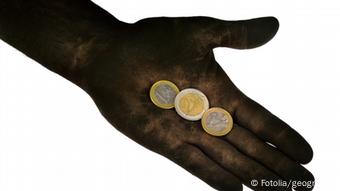 In einer ausgestreckten Hand liegen drei Euro-Münzen