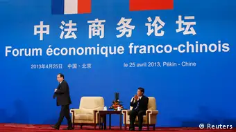 Chinese President Xi Jinping (R) applauds to French President Francois Hollande walking toward a podium to give a speech, during the closing ceremony of China-French Economic Forum at the Great Hall of the People in Beijing April 25, 2013. REUTERS/Kim Kyung-Hoon (CHINA - Tags: POLITICS BUSINESS)