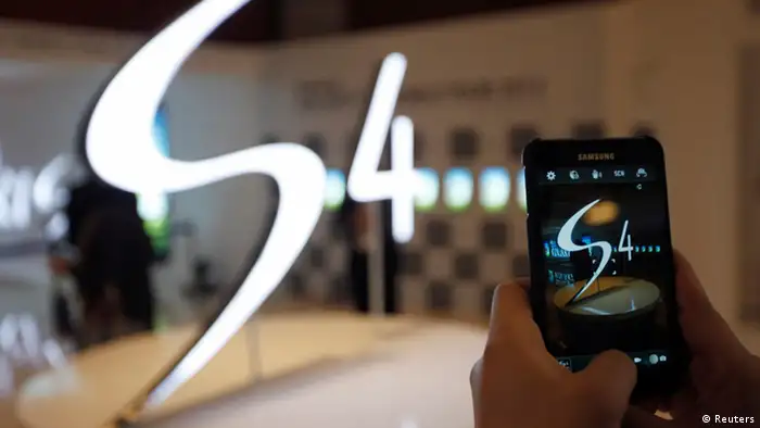 A man takes a photograph of a logo of Samsung Electronics Co Ltd's latest flagship smartphone S4 during its launch event at the company's headquarters in Seoul April 25, 2013. Supply issues have snarled the U.S. rollout of Samsung Electronics Co Ltd's latest flagship smartphone, which will go on sale at carriers Sprint and T-Mobile later than expected, the wireless service providers said on Wednesday. REUTERS/Kim Hong-Ji (SOUTH KOREA - Tags: BUSINESS TELECOMS)
