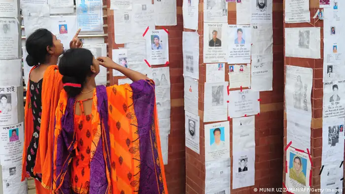 Two Bangladeshi women look at a board with notices posted of missing and dead workers three days after an eight-storey building collapsed in Savar, on the outskirts of Dhaka, on April 27, 2013. Police arrested two textile bosses over a Bangladeshi factory disaster as the death toll climbed to 332 and distraught relatives lashed out at rescuers trying to detect signs of life. AFP PHOTO/ Munir uz ZAMAN (Photo credit should read MUNIR UZ ZAMAN/AFP/Getty Images)