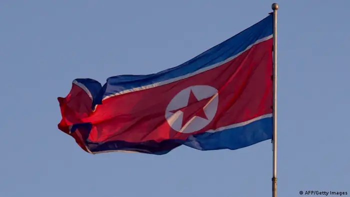 AUSSCHNITT AUS: A soldier stands beneath a North Korean flag prior to celebrations to mark the 100th birth anniversary of the country's founding leader Kim Il-Sung, in Pyongyang on April 16, 2012. The commemorations came just three days after a satellite launch timed to mark the centenary fizzled out embarrassingly when the rocket apparently exploded within minutes of blastoff and plunged into the sea. AFP PHOTO / Ed Jones (Photo credit should read Ed Jones/AFP/Getty Images)