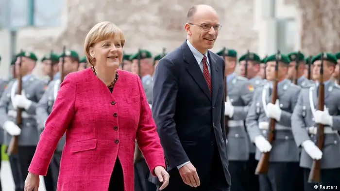 German Chancellor Angela Merkel and Italian Prime Minister Enrico Letta inspect a guard of honour during a welcome ceremony outside the Chancellery in Berlin, April 30, 2013. REUTERS/Tobias Schwarz (GERMANY - Tags: POLITICS)