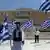 Демонстранты в национальных костюмах с греческими флагами перед парламентом в Афинах