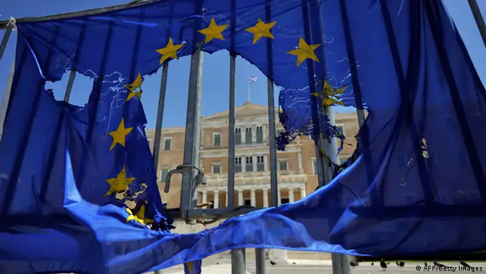 A burned EU flag hangs on the barriers protecting the Greek parliament in Athens on May 1, 2013. Greece's two main unions called a general strike against prolonged austerity on May 1, with protests by unions, students and workers. AFP PHOTO/ LOUISA GOULIAMAKI (Photo credit should read LOUISA GOULIAMAKI/AFP/Getty Images)