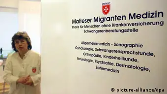 Ein Schild an der Praxistür weist am 13.02.2013 auf die Arztpraxis der Malteser Migranten Medizin in Berlin hin. Der Berliner Erzbischof Kardinal Woelki übernahm die Schirmherrschaft für die Praxis, die Patienten ohne Krankenversicherung behandelt. Foto: Stephanie Pilick/dpa +++(c) dpa - Bildfunk+++