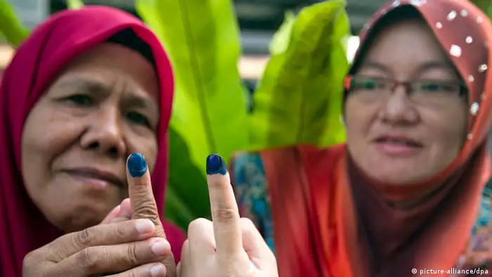 Malaysian woman show their inked fingers after they casting their votes in the country's May 2013 election. (Photo: Ahmad Yusni)