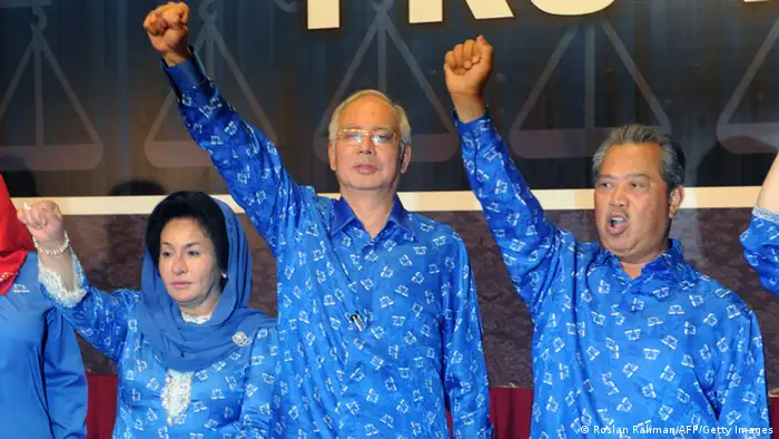 Malaysian Prime Minister Najib Razak (C), his wife Rosmah Mansor (L) and deputy Prime Minister Muhyiddin Yassin celebrate the Barisan Nasional (National Front) coalition electoral victory, on May 6, 2013 in Kuala Lumpur. Country's Election Comission said the ruling Barisan Nasional coalition led by Premier Najib Razak secured 112 parliamentary seats, the threshold required to form a government in the 222-seat chamber. Malaysians voted in record numbers in the general election but the hotly anticipated day was dogged by accusations of electoral irregularities. AFP PHOTO / ROSLAN RAHMAN (Photo credit should read ROSLAN RAHMAN/AFP/Getty Images)