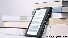 Ein eReader an einen Bücherstapel gelehnt