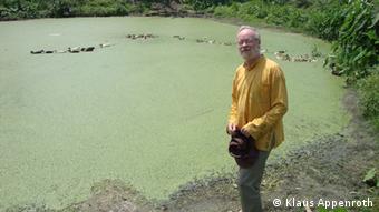 Klaus Appenroth vor einem Teich, der übersäht von Wasserlinsen ist. (Foto: Klaus Appenroth)