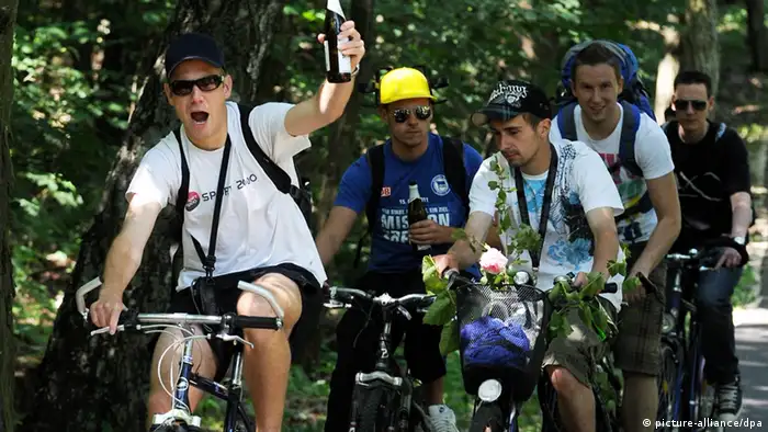 Eine Gruppe junger Männer auf Fahrrädern mit Bierflaschen in Händen bei Schmöckwitz - Foto: Tim Brakemeier (dpa)