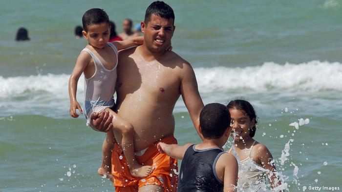 A Tunisian family enjoys swimming in the la Marsa sea in the summer Copyright: FETHI BELAID/AFP/Getty Images)