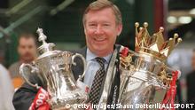 12th May 1996; Manchester United manager Alex Ferguson with the FA Cup and Premiership trophy on his arrival at Manchester's Victoria station. Mandatory Credit: Shaun Botterill/ALLSPORT
