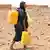 A woman in Mauritania carries cans to fill them with water (Photo: ABDELHAK SENNA/AFP/GettyImages)