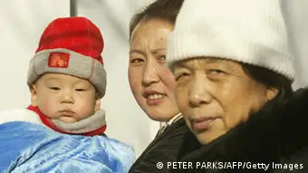 Three generations of a family, baby, mother and grandmother walk together on a street in Beijing 04 January 2005. The population in China, the worlds most populous nation, will officially hit 1.3 billion this week according to state-run Xinhua news citing government figures. AFP PHOTO/Peter PARKS (Photo credit should read PETER PARKS/AFP/Getty Images)