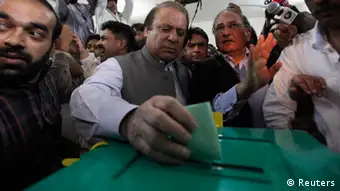 Nawaz Sharif (C), leader of the Pakistan Muslim League - Nawaz (PML-N) political party, casts his vote for the general election at a polling station in Lahore May 11, 2013. A string of militant attacks cast a long shadow over Pakistan's general election on Saturday, but millions still turned out to vote in a landmark test of the troubled country's democracy. REUTERS/Mohsin Raza (PAKISTAN - Tags: POLITICS ELECTIONS TPX IMAGES OF THE DAY)