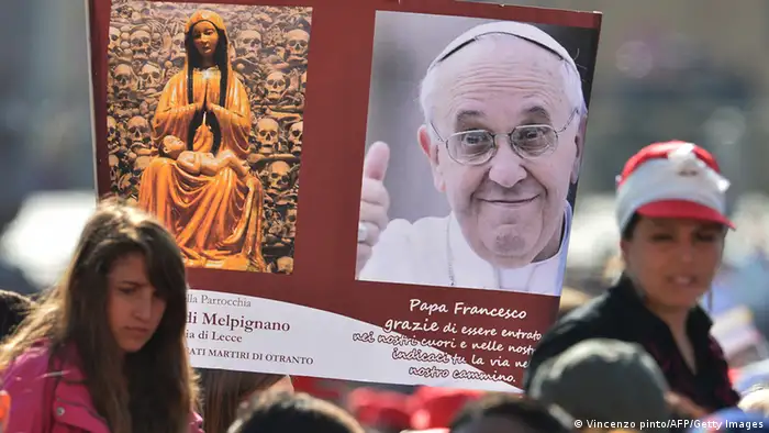 Faithfuls hold up a poster in St.Peter's square at the Vatican on May 12, 2013, during the Canonization mass led by the Pope of Italian Antonio Primaldo and companions, Colombian Laura Montoya Upegui and Mexican Maria Guadalupe Garcia Zavala. Pope Francis created the first saints of his reign, canonizing some 800 Italian martyrs who refused to convert to Islam in the 15th century, as well as a Colombian and a Mexican who founded congregations. AFP PHOTO/ VINCENZO PINTO (Photo credit should read VINCENZO PINTO/AFP/Getty Images)