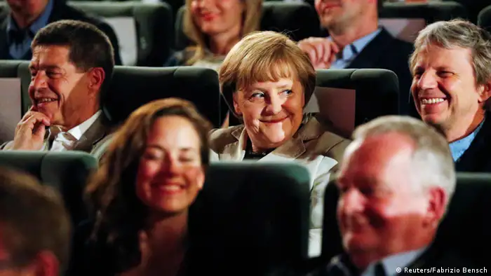 German Chancellor Angela Merkel (C), her husband Joachim Sauer (L) and German film director Andreas Dresen (R) wait for the screening of the former East German classic film The Legend of Paul and Paula at a cinema in Berlin, May 12, 2013. Merkel was invited to select the movie for Sunday evening's film screening, as part of the German Film Academy series My Film, where a prominent figure from the political or cultural sphere chooses a film for the evening and explains its significance to audiences. REUTERS/Fabrizio Bensch (GERMANY - Tags: ENTERTAINMENT POLITICS TPX IMAGES OF THE DAY)