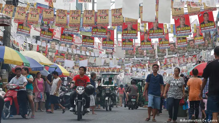 Election posters for the midterm elections hang along a street as residents walk to a polling precinct in Taguig, Metro Manila May 13, 2013. More than 50 million Filipinos will cast their votes for a new set of lawmakers and local officials on Monday, a referendum of sorts halfway through the six-year term of Philippine President Benigno Aquino who tackled corruption and restored business confidence that led to credit-rating upgrades. REUTERS/Erik De Castro (PHILIPPINES - Tags: POLITICS ELECTIONS)