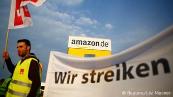 Ein Mitarbeiter des Online-Versandzentrums von Amazon in Deutschland mit einem Streikbanner. Foto: REUTERS/Lisi Niesner (GERMANY - Tags: BUSINESS EMPLOYMENT CIVIL UNREST)