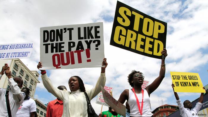 Kenyans wave signs saying: Don't like the pay? Quit! and Stop Greed