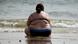 An overweight woman sits on a beach on a dark English seashore (Photo: Matt Cardy/Getty Images) An overweight woman sits on a beach on a dark English seashore (Photo: Matt Cardy/Getty Images)