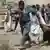 Polizisten tragen Verletzte weg nach dem Selbstmordanschlag in der Provinz Baghlan (foto: AP)