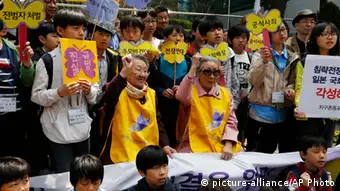 South Koreans, Kim Bok-dong, 87, center right, and Gil Wen-oak, 84, center left, who were forced to serve for the Japanese Army as sexual slaves, so called comfort women, during World War II, shout slogan with their supporters in an anti-Japan protest against the Japanese lawmakers' visit to the Yasukuni Shrine, in front of the Japanese Embassy in Seoul, South Korea Wednesday, April 24, 2013. Visits by Japanese Cabinet ministers and lawmakers to the shrine honoring Japan's war dead, including 14 World War II leaders convicted of atrocities, signal Japanese Prime Minister Shinzo Abe's determination to pursue a more nationalist agenda after months of focusing on the economy. The Korean read Disclose the truth, Official apology and compensation and punish the criminal. (AP Photo/Kin Cheung)