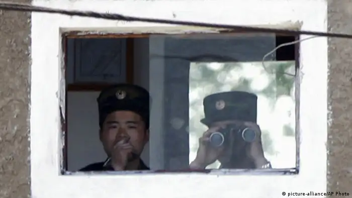 North Korean soldiers watch Chinese side from border town Simuiju, North Korea, as they are seen from Dandong, northeastern Liaoning province of China, Monday, May 20, 2013. North Korea fired a short-range projectile into its own eastern waters Monday for the fifth time in three days, Seoul officials said, as Pyongyang threatened to retaliate against any outside criticism of its rocket tests meant to bolster defense against what it calls U.S. and South Korean threats to attack. (AP Photo/Kyodo News) JAPAN OUT, MANDATORY CREDIT